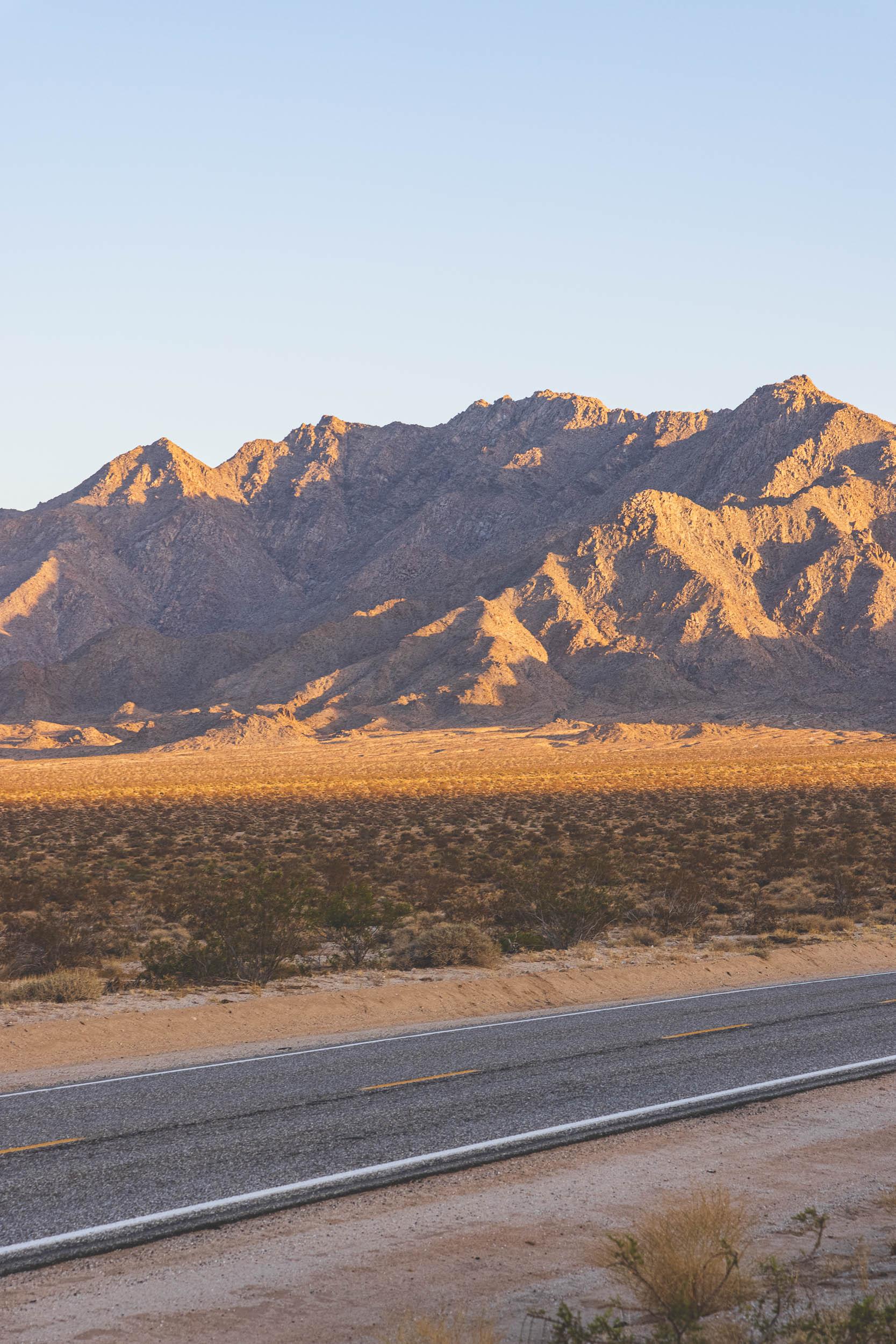 Mountains on the horizon above a two-lane desert highway