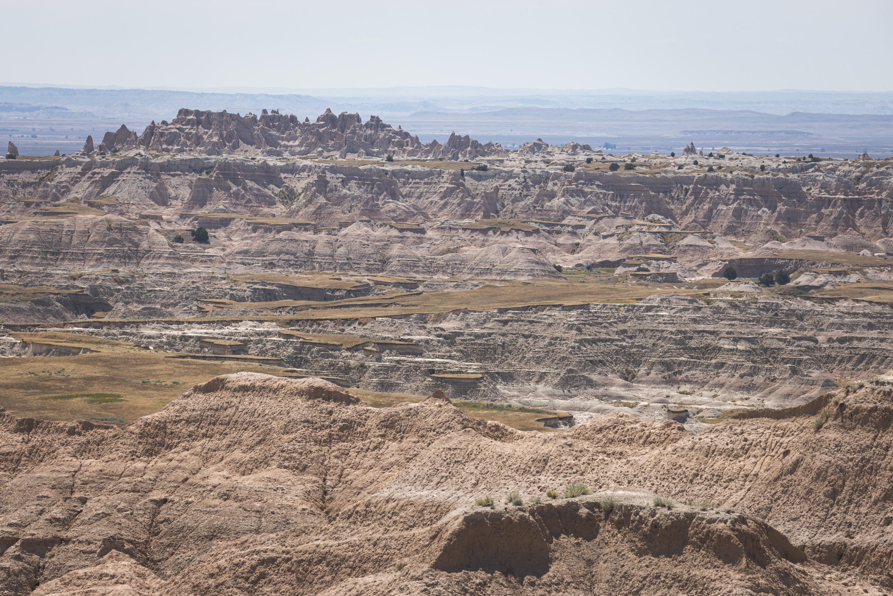A view into the distance showing rocky terrain occasionally pierced by patches of smooth grassland
