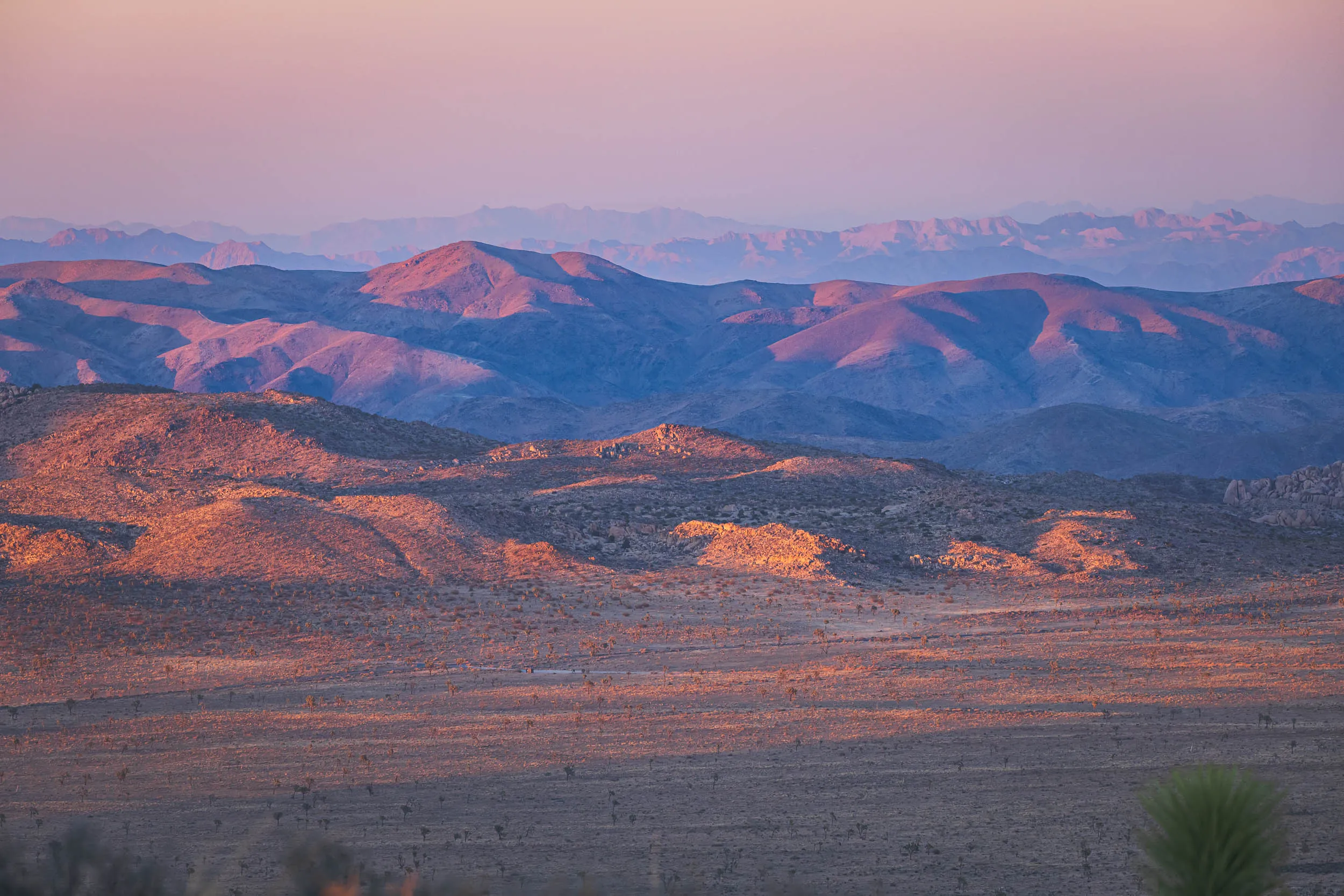 The setting sun casts a warm glow on the foothills of southern California