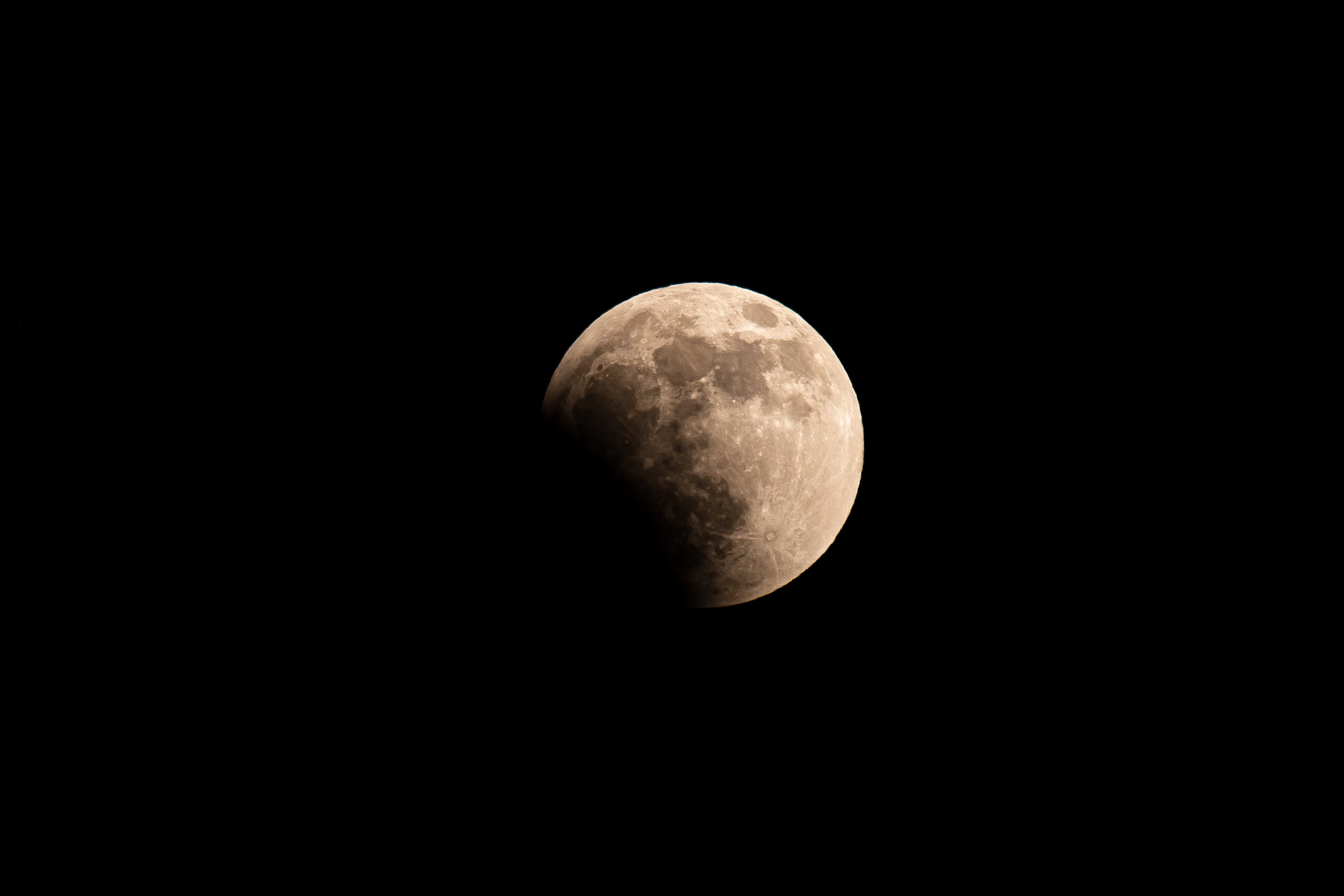 The full moon during a lunar eclipse, showing even more of the lower left portion covered in shadow