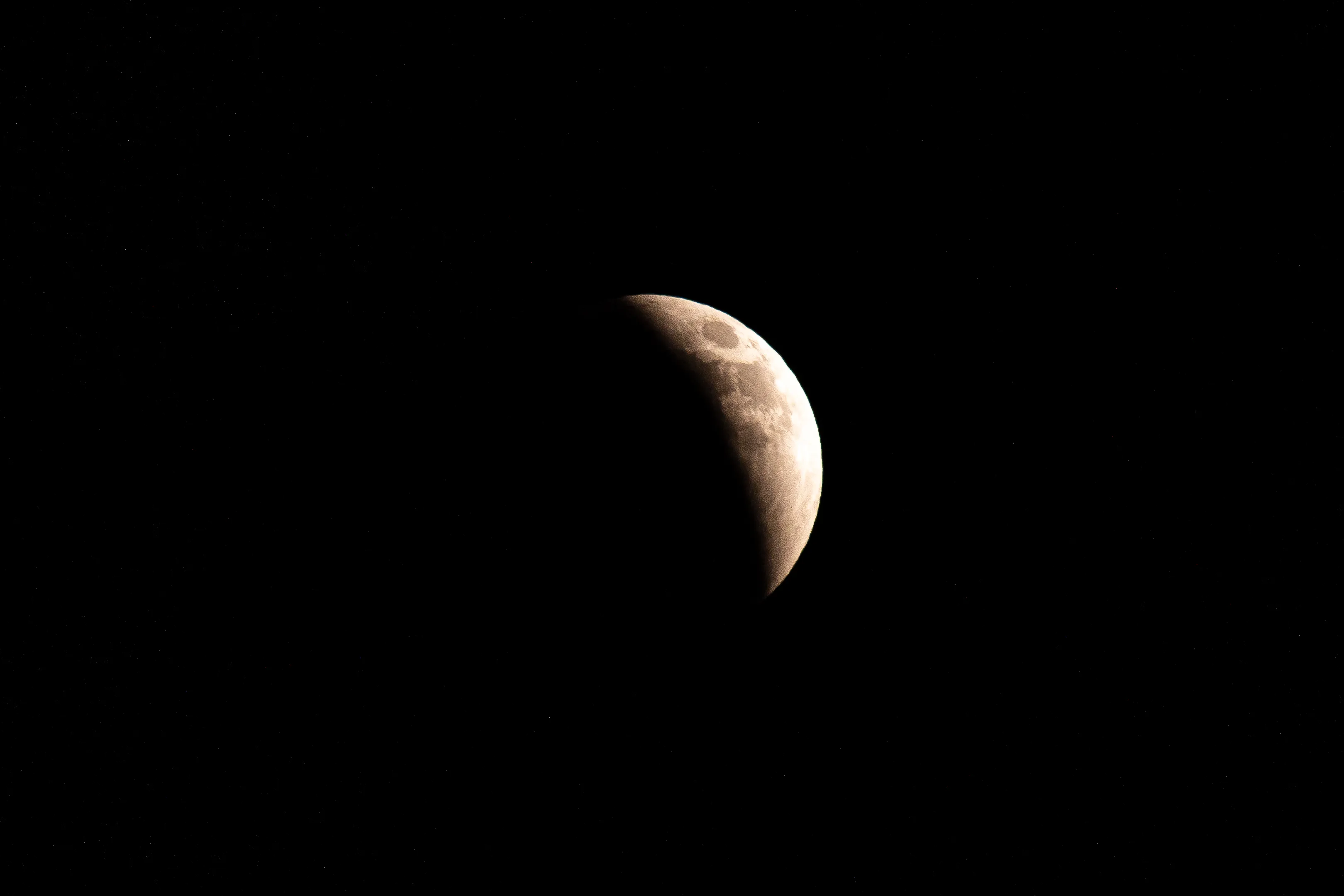 The full moon during a lunar eclipse, increasingly obscured by shadow