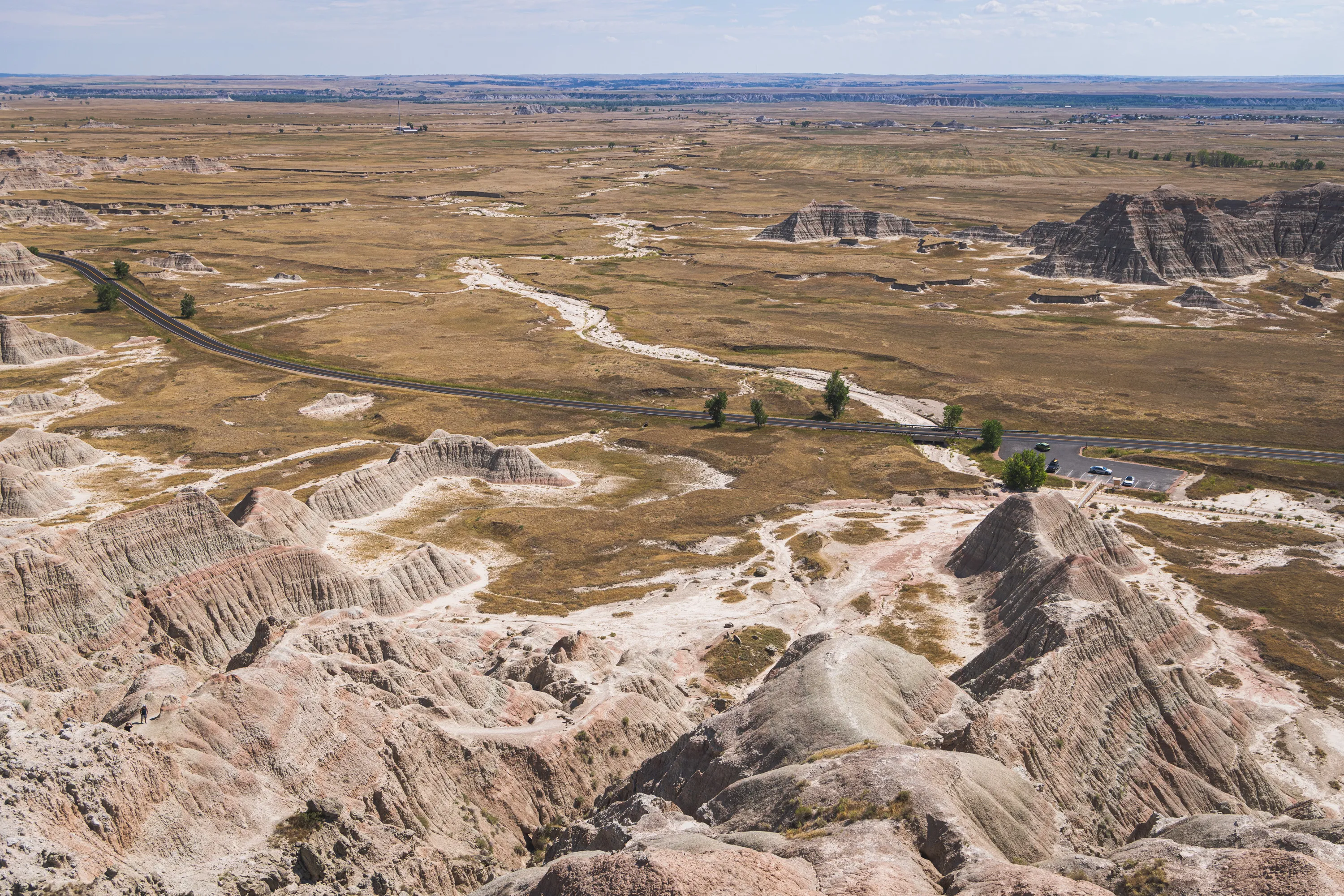 A view of the small parking lot where I left my car before hiking a few hundred feet up the mountain where I now stand. You can see far into the distance of grassland.