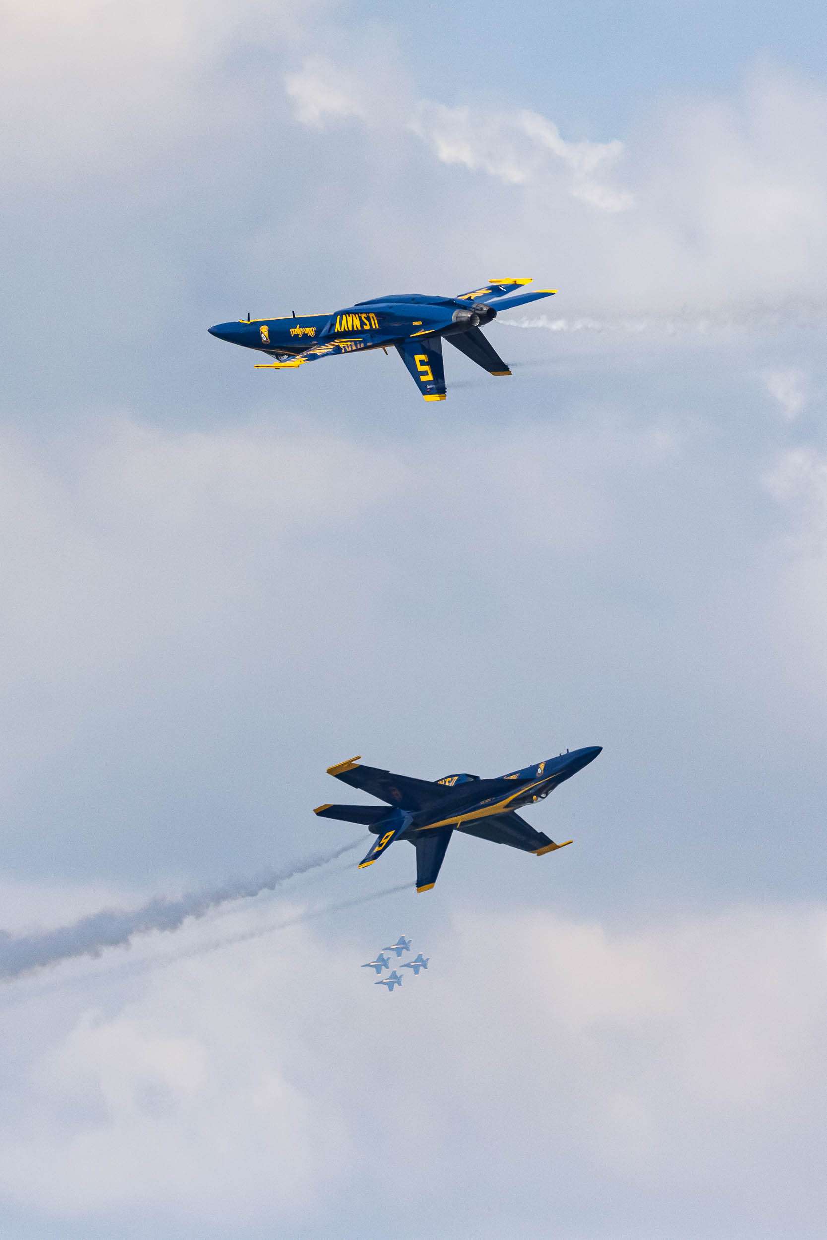 Two Blue Angels converge with four other jets in the background