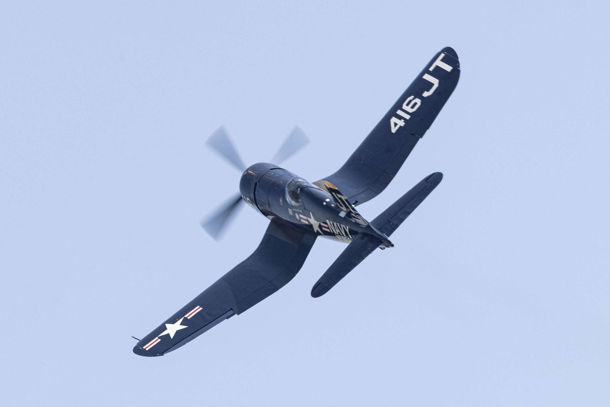 An F4U-4 Corsair climbing into the sky