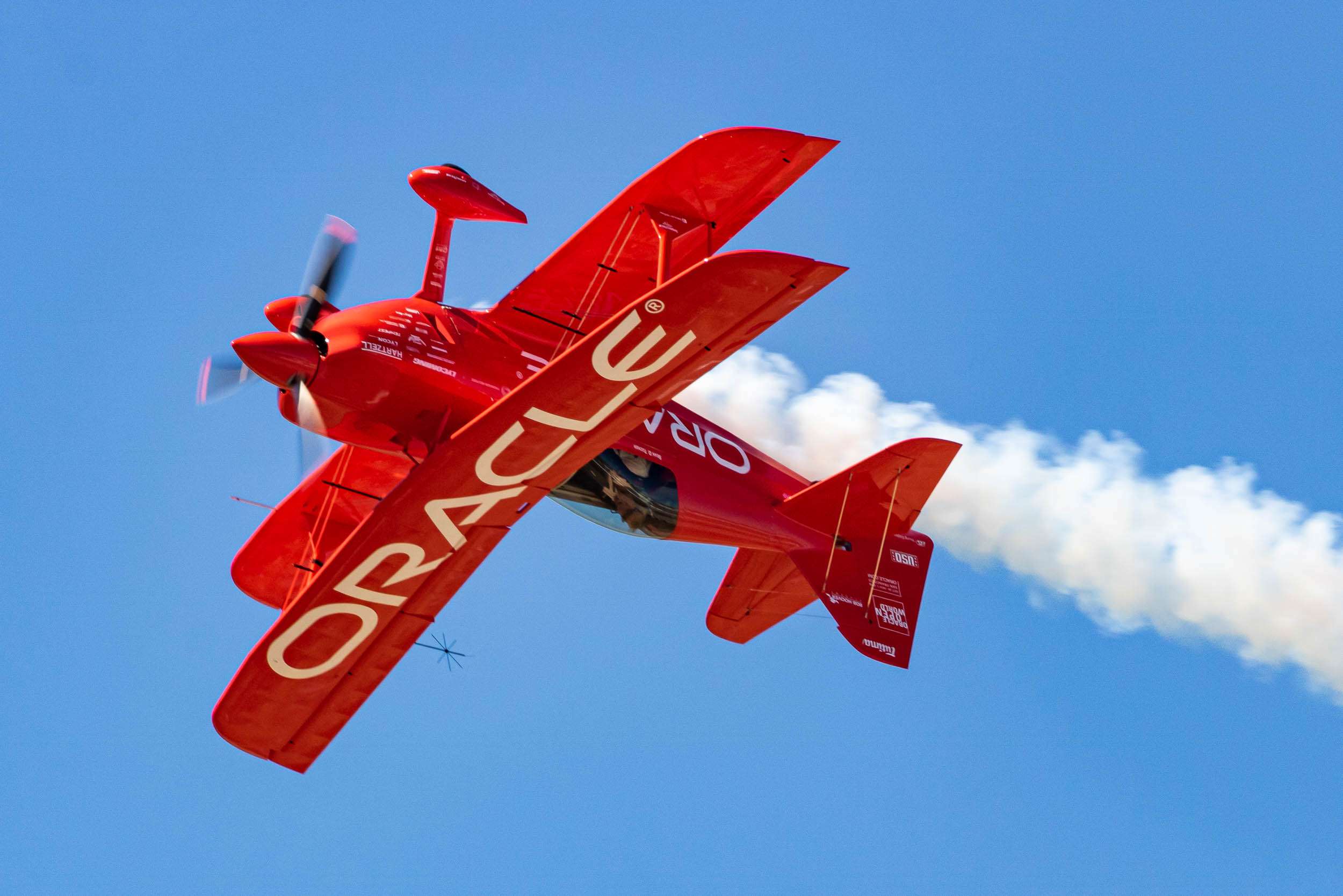Sean D. Tucker flying inverted in the red Oracle Challenger III biplane