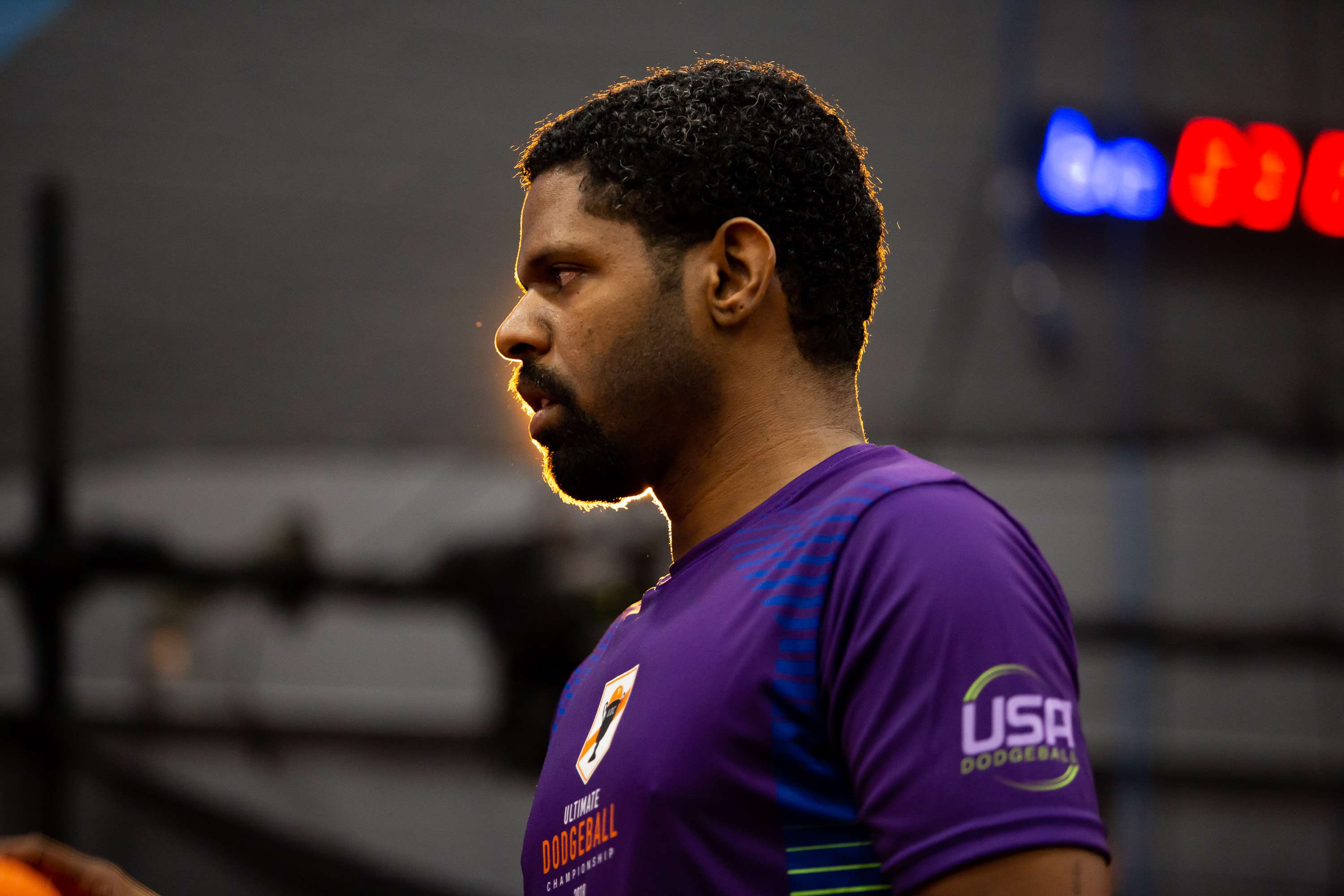 A player walks onto the court while silouetted against a bright light